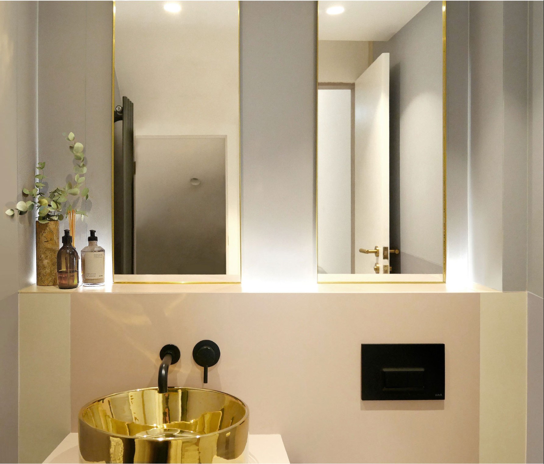 Cloakroom with gold basin and custom mirrors